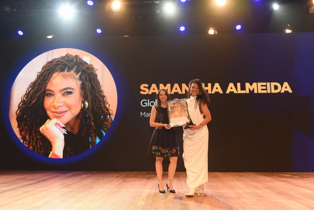 Samantha Almeida, da Globo, recebe o Troféu Garra na categoria Marketing e Marcas, entregue por Marianna Cruz, da APP Brasil. Crédito: Divulgação